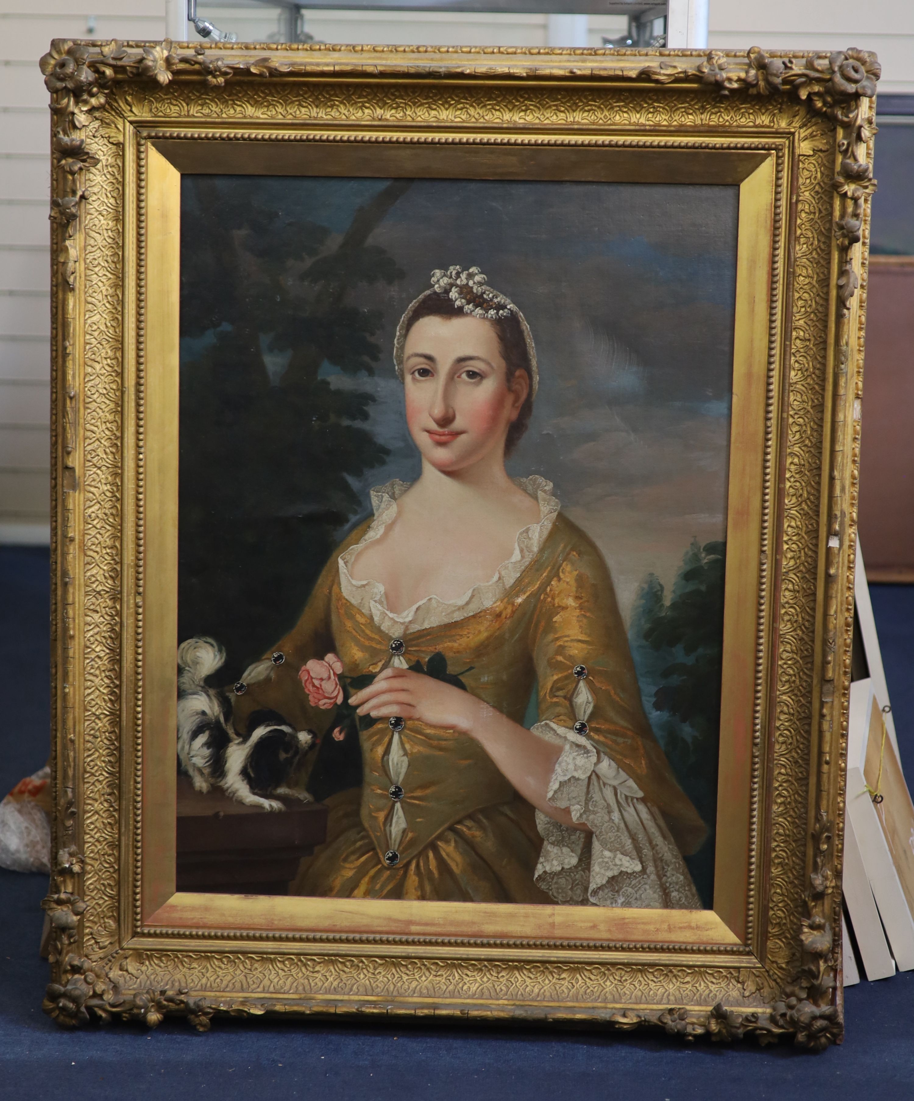 Early 18th century French School, Portrait of a lady wearing a yellow dress holding a rose with a lap dog beside her, oil on canvas, 82 x 62cm